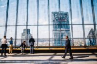 Business professionals in a modern London office with the City skyline in view